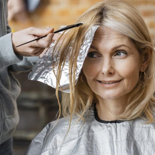 mujer-obteniendo-su-cabello-tenido-por-peluquero-en-casa