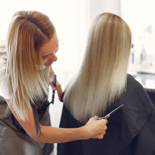 peluqueria-corto-el-cabello-de-su-cliente-en-una-peluqueria